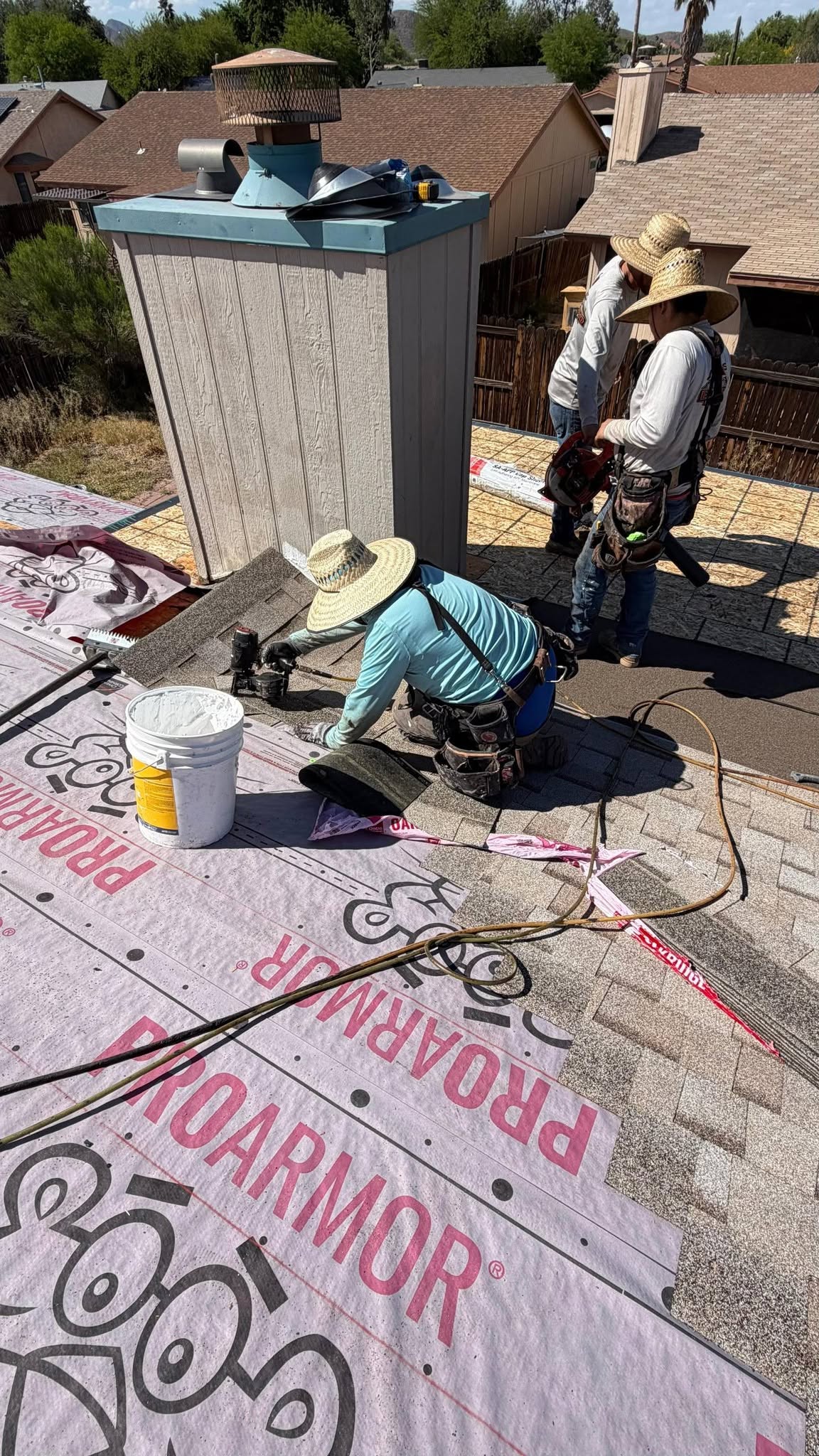 Grand Valley Roofing crew installing asphalt shingles over roofing underlayment.